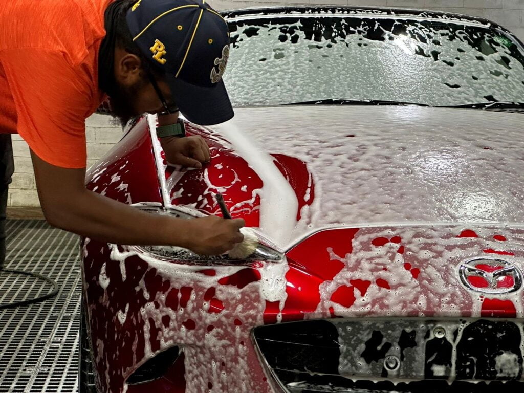 Car Wash 1 A person washing a red Mazda with brush